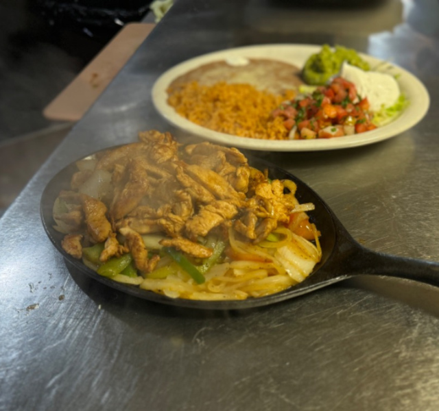 Sizzling grilled chicken fajitas with peppers and onions at La Tapatia