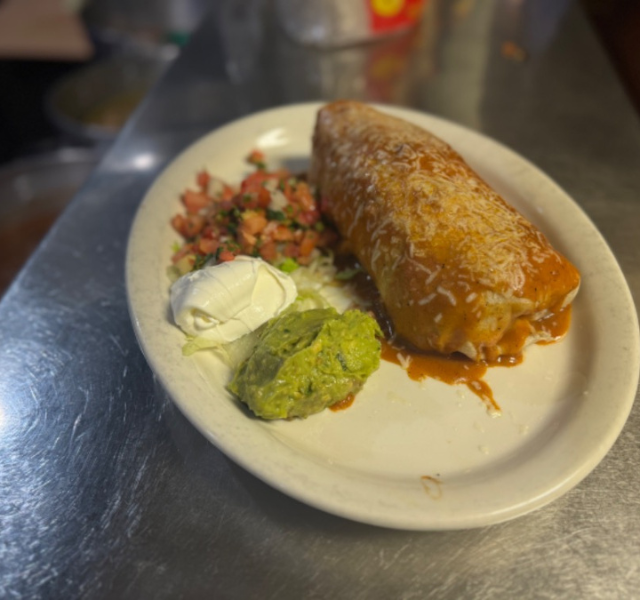 Super burrito with ground beef, with tomato salad, white sour sause and guacamole at La Tapatia