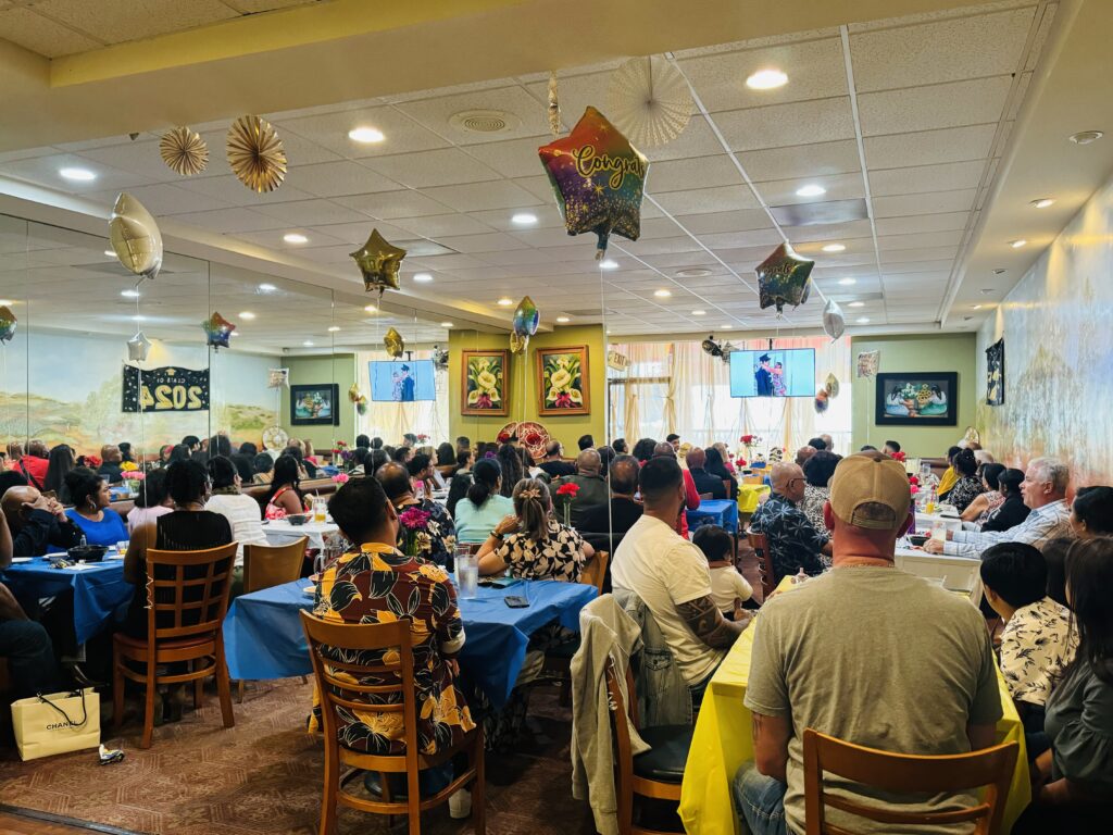 Event going on at La Tapatia banquet hall where several people sitting and enjoying memories on tv